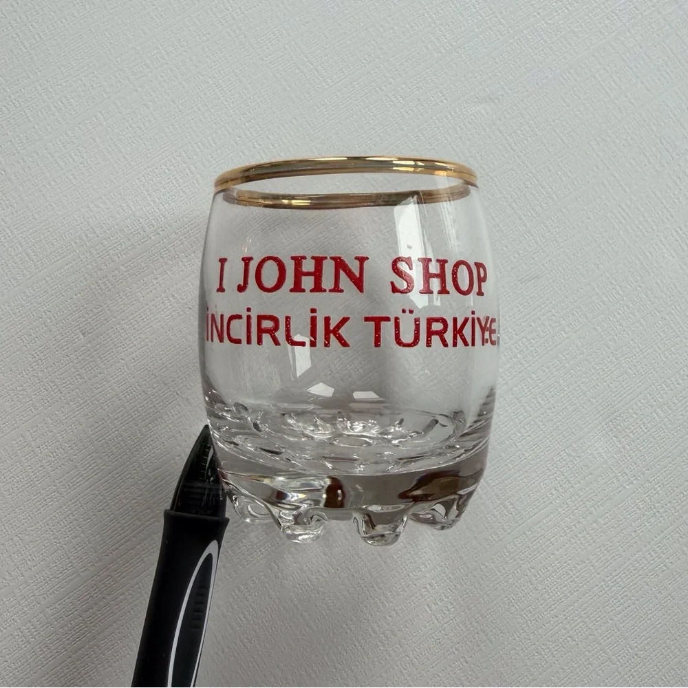 VTG I John Shop in‎ Incirlik, Türkiye shot glass in a gold rim & bold red text